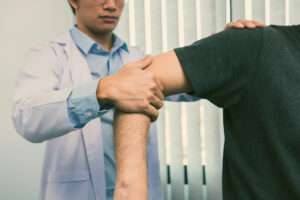 Physical therapists press to the patient shoulder check for pain.